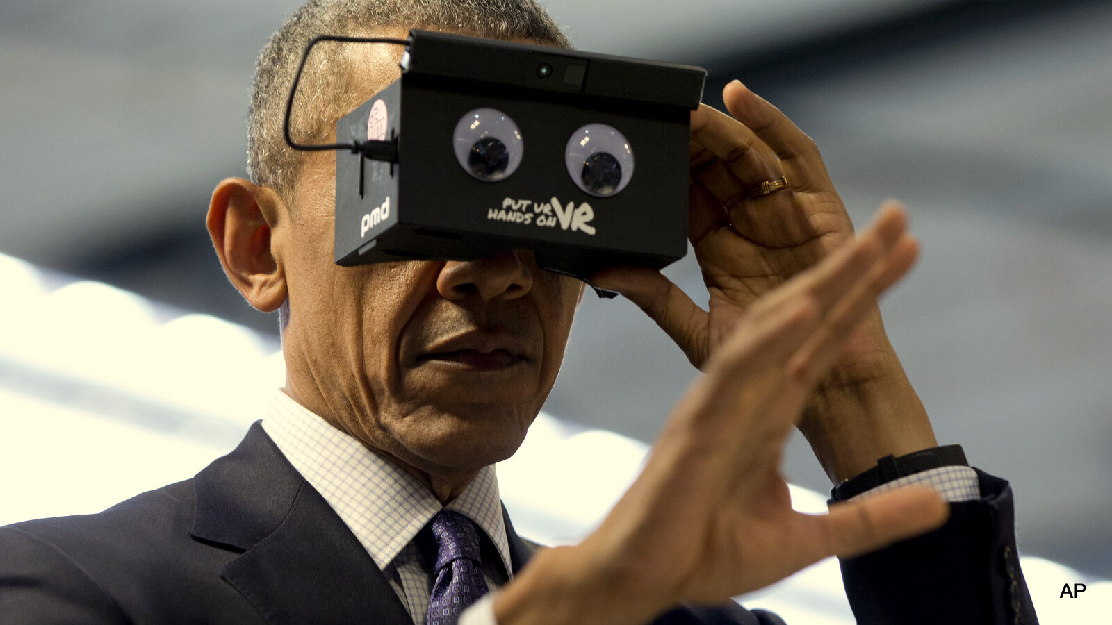 U.S. President Barack Obama looks at his hand as he tests VR goggles when touring the Hannover Messe, the world's largest industrial technology trade fair, in Hannover, northern Germany, Monday, April 25, 2016. Obama is on a two-day official visit to Germany. (AP Photo/Carolyn Kaster)