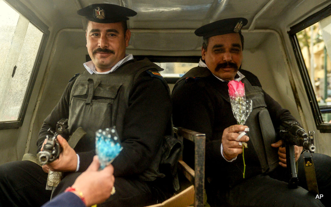 Supporters of Egypt's President Abdel Fattah el-Sissi give out flowers to policemen on Police Day in Tahrir Square, Cairo, Egypt.