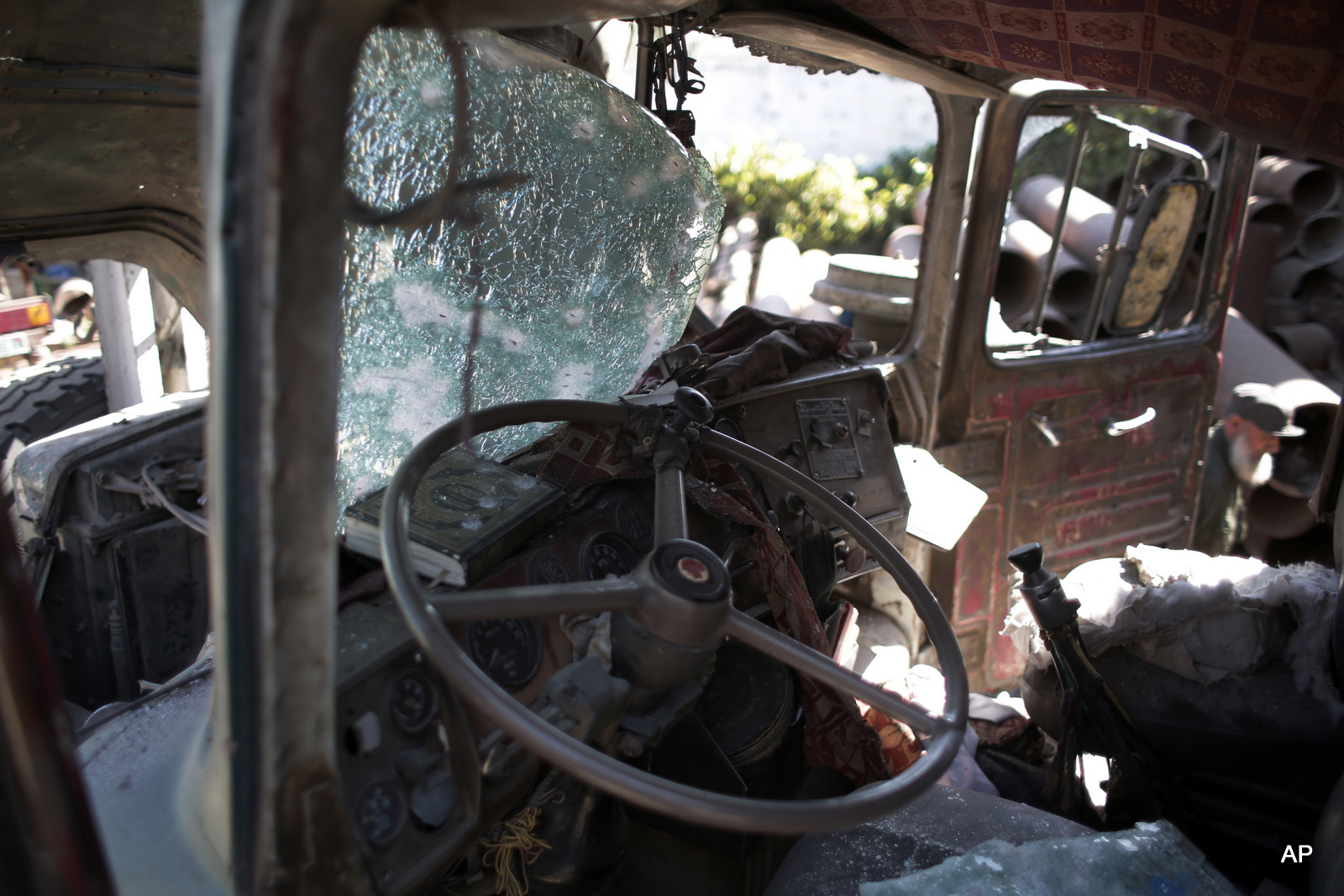 A Palestinian man inspects a damaged artesian well drilling truck after an early morning Israeli airstrike hit a workshop in Gaza City, Thursday, May 5, 2016. (AP Photo/ Khalil Hamra)