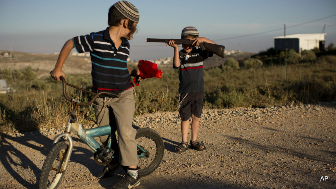 In this Wednesday, May 18, 2016 photo, Jewish settler boys play with toy guns in Amona, an illegal Israeli settlement in the West Bank, Palestine near the town of Ramallah. It is the largest of about 100 settlements in the West Bank which were built without permission but generally tolerated by the Israeli government.