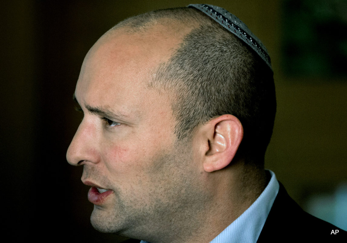 Naftali Bennett, leader of the Jewish Home party, speaks during an interview to The Associated Press in Jerusalem. Israel’s high school civics textbook, slated to be published in March, has become the latest in a string of national battles over what Israeli students learn in school. Three textbook authors have removed their names from chapters they wrote, claiming Education Ministry professionals altered their work beyond recognition. Education Minister Bennet defended the content of the book as “excellent and professional.”