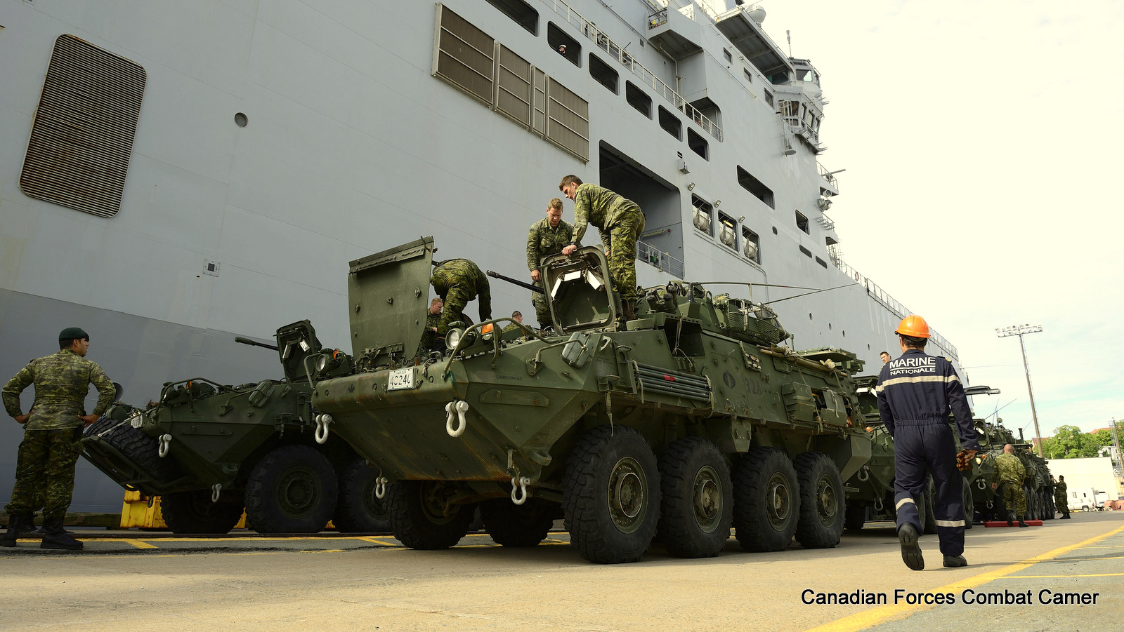 Members of 1st Battalion, Royal 22e Régiment prepare to board their light armoured vehicles on to the French Navy Ship Le Mistral.