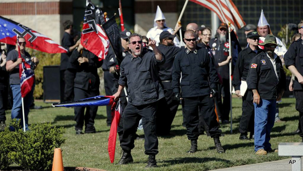 In this Saturday, April 23, 2016 photo, members of the Ku Klux Klan participate in a "white pride" rally in Rome, Ga. Klan leaders say they feel that U.S. politics are going their way, as a nationalist, us-against-them mentality deepens across the nation.