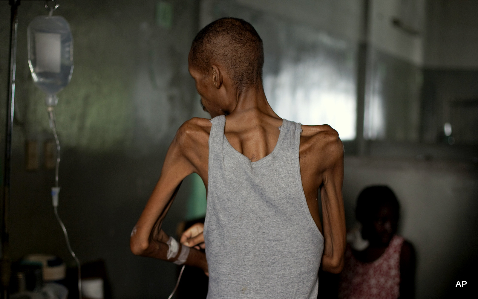 A patient stands as he adjusts his intravenous line at the Red Cross funded State University of Haiti Hospital in Port-au-Prince, Friday, July 9, 2010.