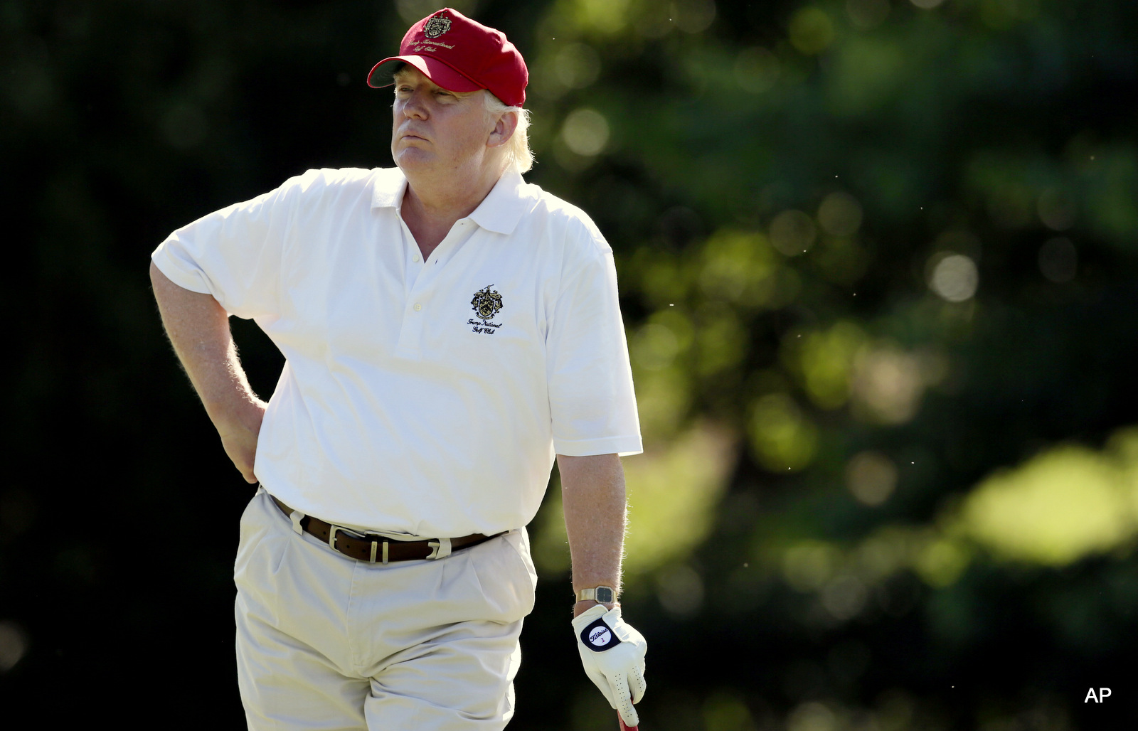 Donald Trump stands on the 14th fairway during a pro-am round of the AT&T National golf tournament at Congressional Country Club in Bethesda, Md.