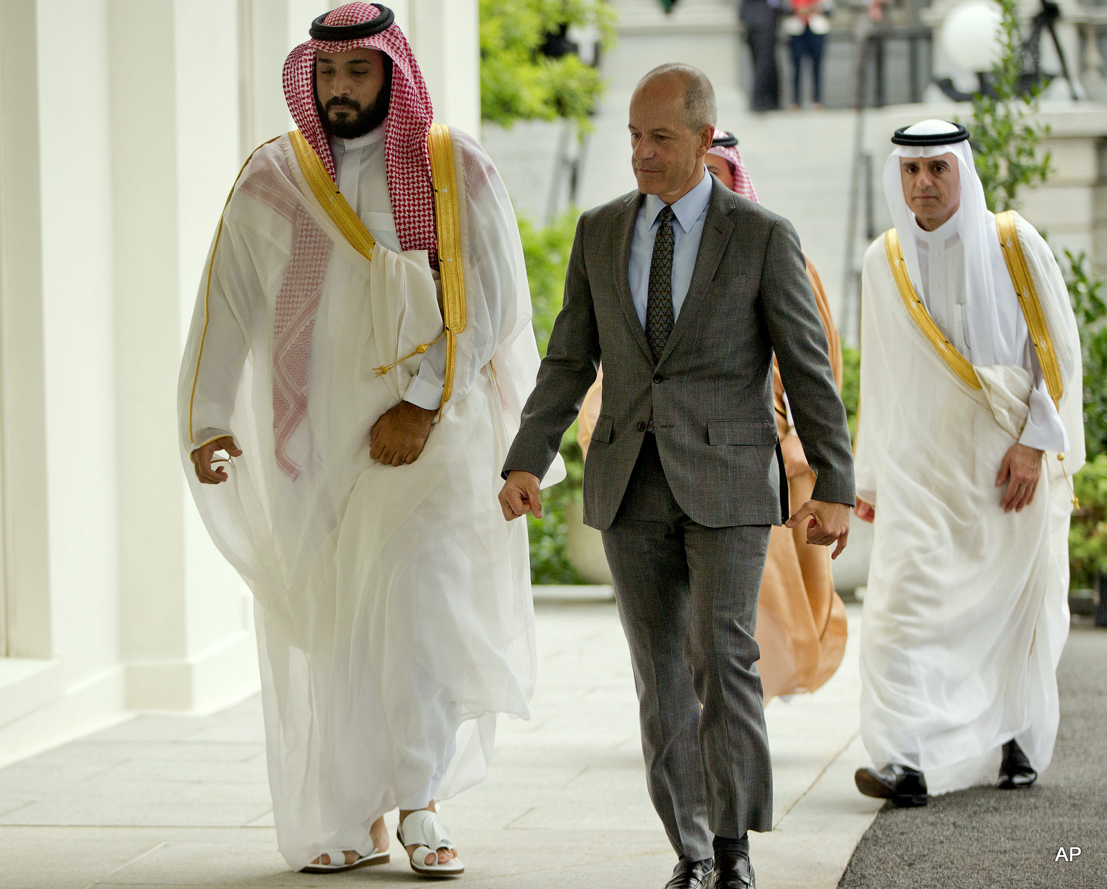 Saudi Arabia's Deputy Crown Prince Mohammed bin Salman, left, walks into the West Wing of the White House in Washington escorted by Mark E. Walsh, center, Deputy Chief of Protocol, Friday, June 17, 2016.