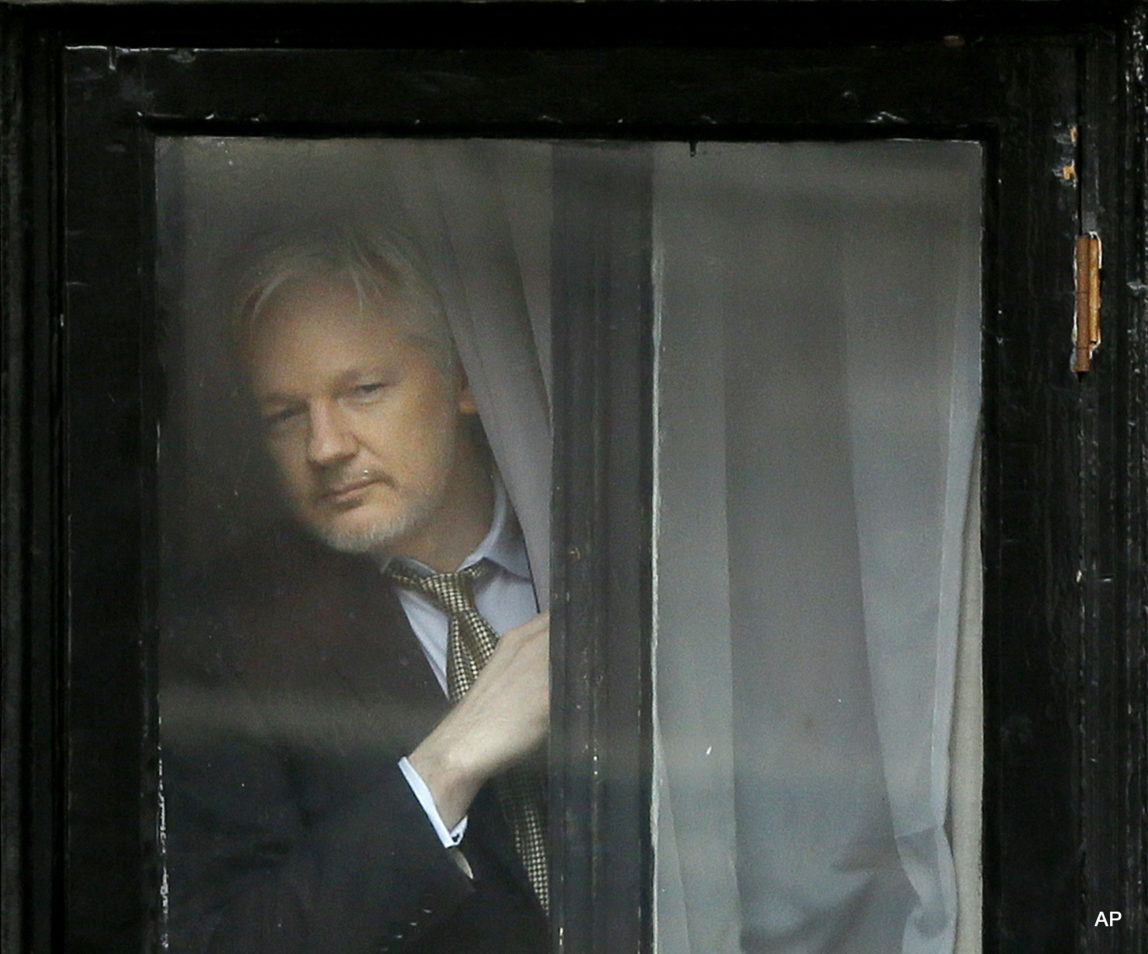 Wikileaks founder Julian Assange appears at the window before speaking on the balcony of the Ecuadorean Embassy in London, Friday, Feb. 5, 2016.