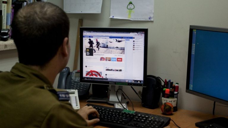 Am Israeli soldier looks at the IDF's Facebook page at the army spokesperson's office in Jerusalem.