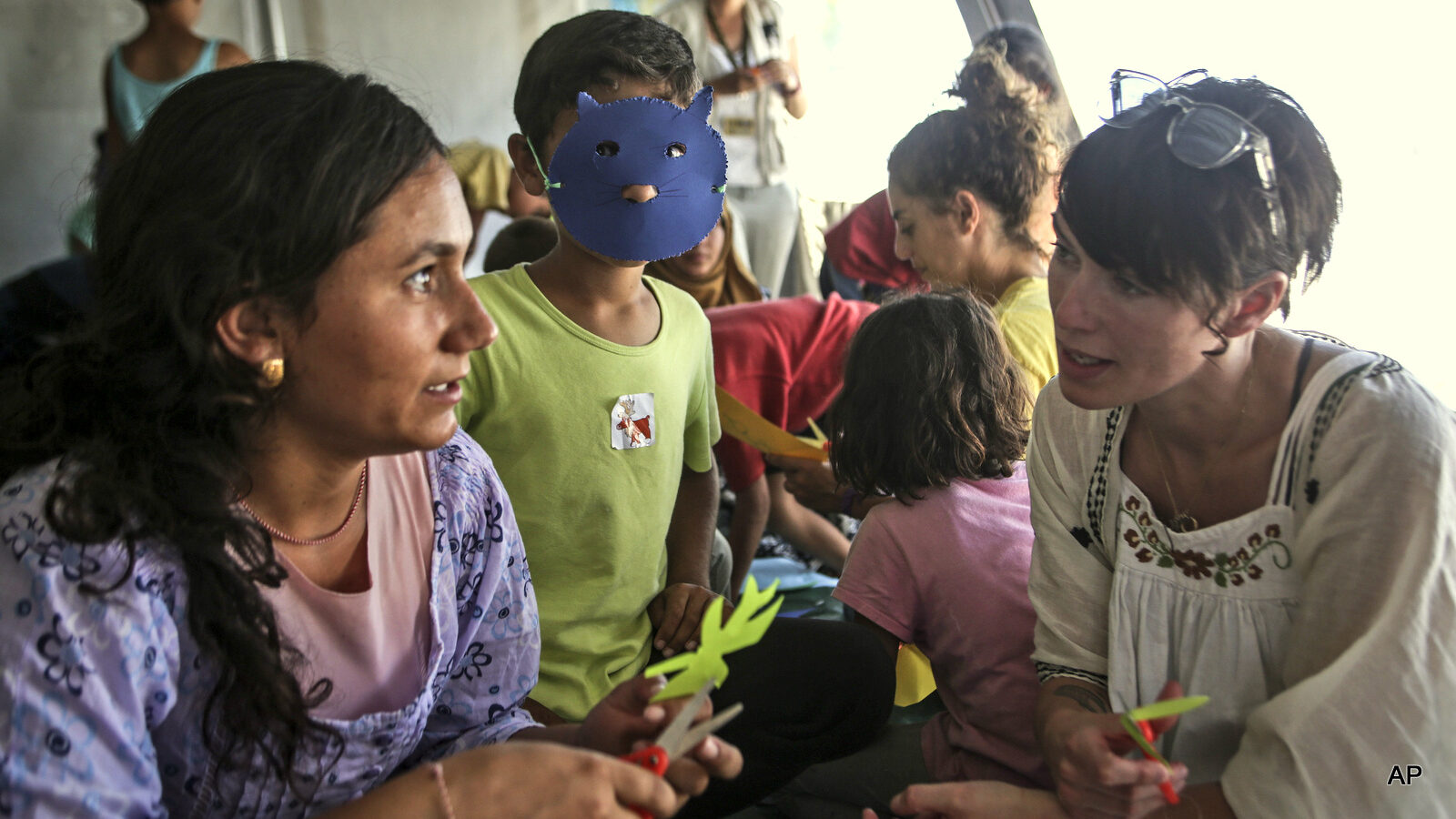 In this Thursday, June 30, 2016 handout photo provided by the International Rescue Committee, Lena Headey, right, talks with young Syrian children at Cherso refugee camp in northern Greece. Game of Thrones star Lena Headey traveled to Greece with co-stars in the TV fantasy drama Liam Cunningham and Maisie Williams to visit refugee camps with the relief organization, the International Rescue Committee.