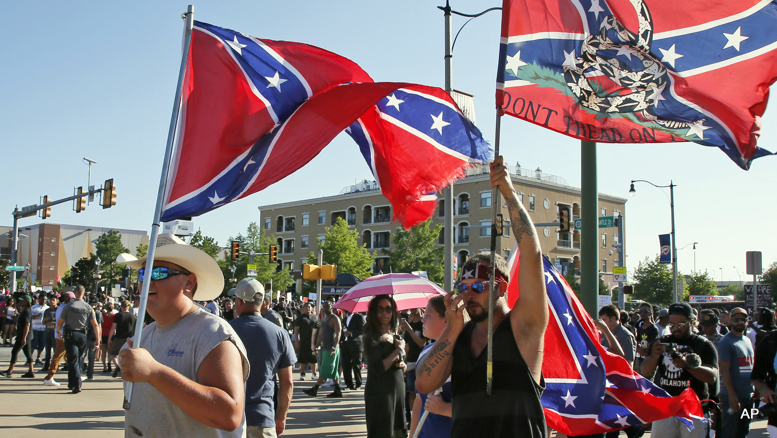 Counter-protesters carry confederate flags past a Black Lives Matter rally in Oklahoma City, Sunday, July 10, 2016.