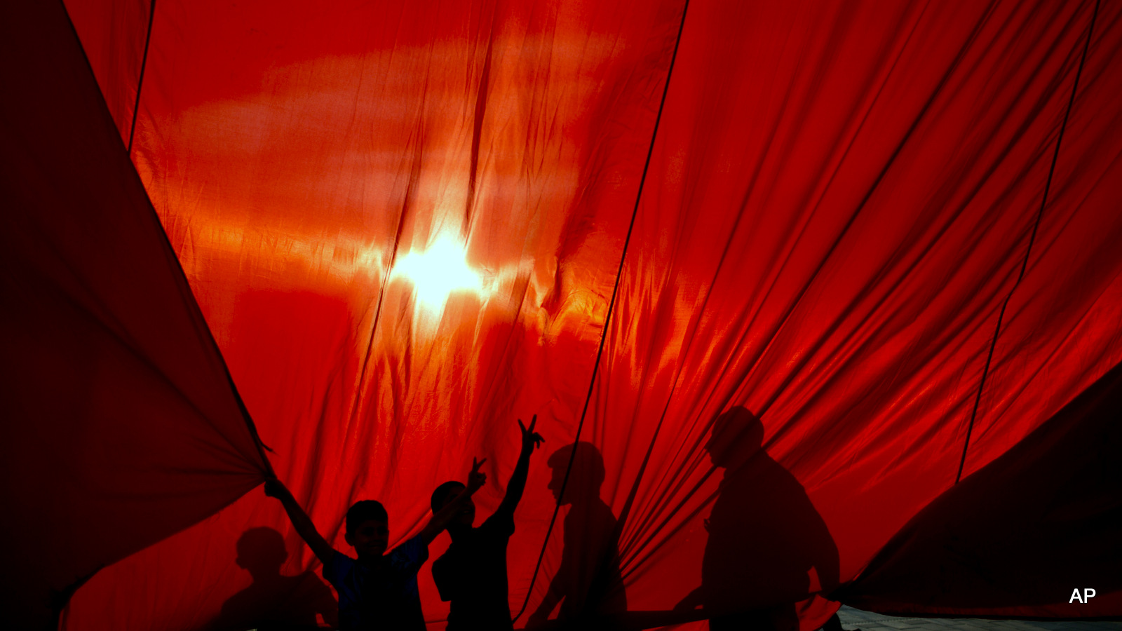 Protesters hold a giant Turkish flag as they gather in Taksim Square in Istanbul, Monday, July 18, 2016. Turkey's Interior Ministry has fired nearly 9,000 police officers, bureaucrats and others and detained thousands of suspected plotters following a foiled coup against the government, Turkey's state-run news agency reported Monday.