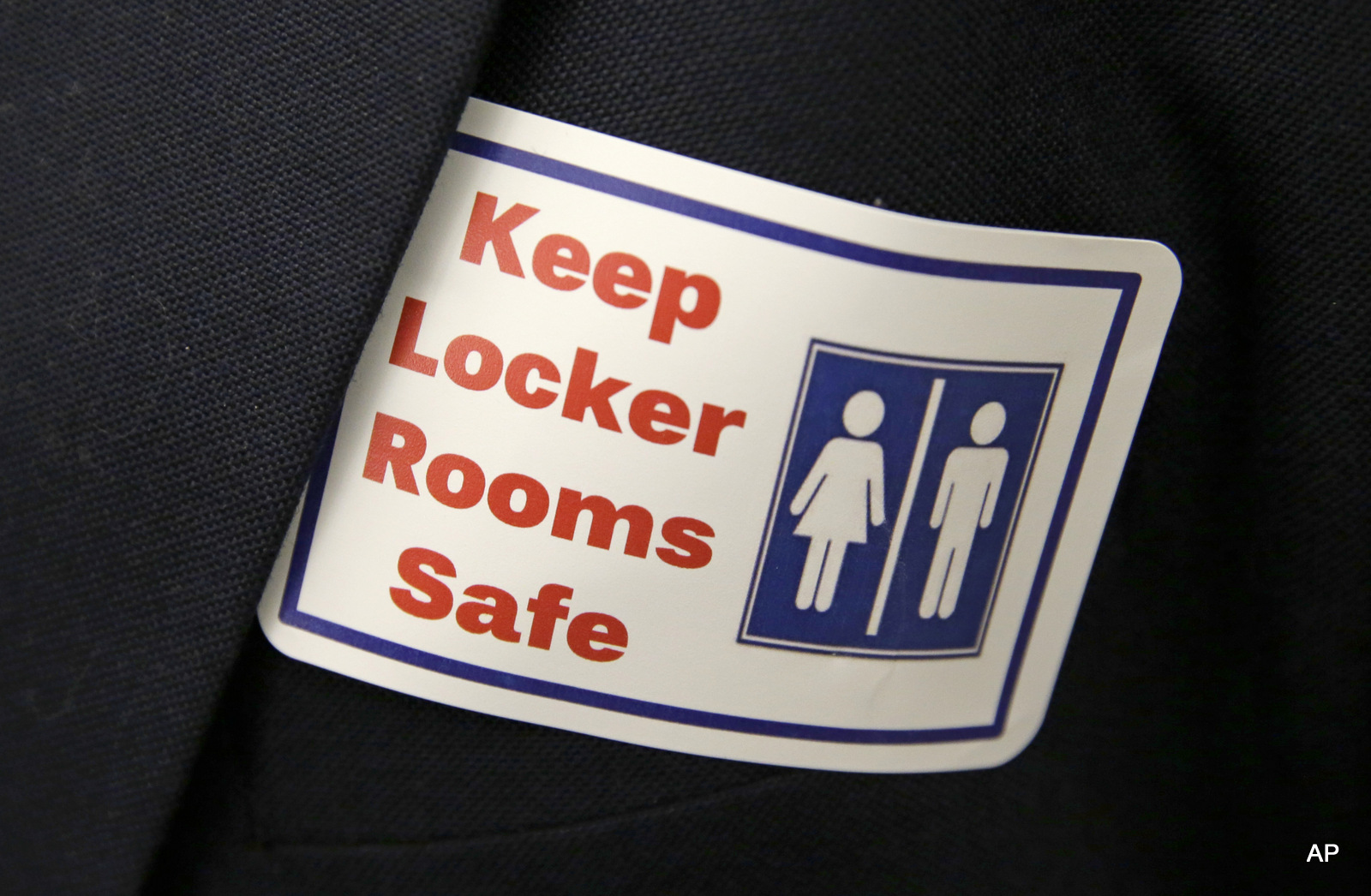 A sticker that reads, "Keep Locker Rooms Safe," is worn by a person supporting a bill that would eliminate Washington's new rule allowing transgender people use gender-segregated bathrooms and locker rooms in public buildings consistent with their gender identity, Wednesday, Jan. 27, 2016, outside a Washington Senate hearing room at the Capitol in Olympia, Wash.