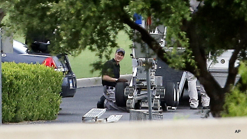 Police setup a remotely operated robot during a stand off with a gunman barricaded inside a van at a Jack in the Box restaurant at Interstate 45 and Dowdy Ferry Road, Saturday, June 13, 2015, in Hutchins, Texas. The same type of device was used to kill the suspected gunmen in the recent attack on police in Dallas, Texas.
