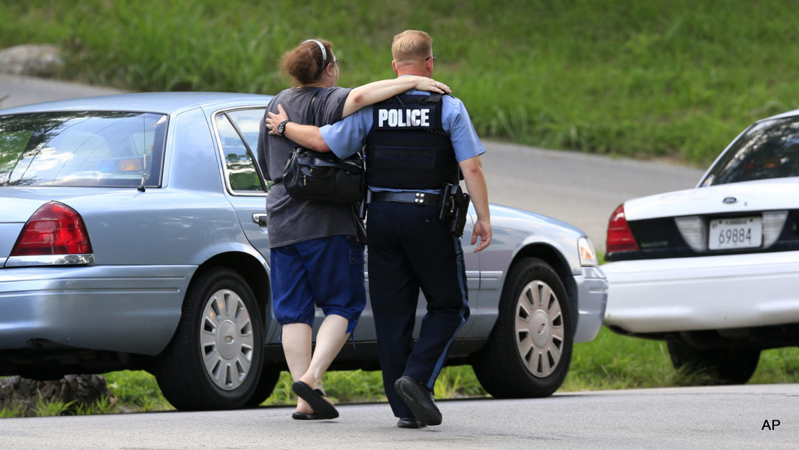 Kansas City, Kan., police officer Brad Lightfoot, right, walks Susan Goble to the shooting scene of a police officer in Kansas City, Kan., Tuesday, July 19, 2016. Goble knows the family of the fallen officer and hoped to place a wreath near the site of the shooting.