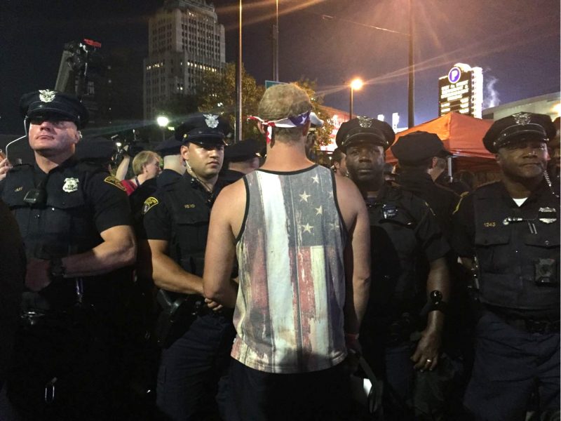 In this July 18, 2016 photograph, Cleveland police and a protester embrace outside the Quicken Loans Arena, site of the 2016 Republican National Convention. (MintPress News / Desiree Kane)