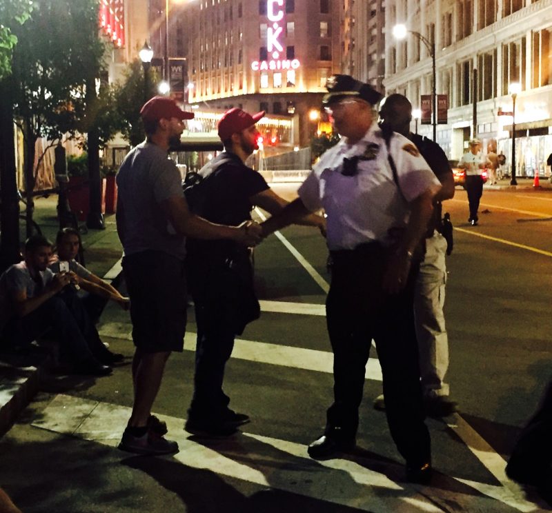 In this July 18, 2016 photograph, police shake hands with a pair of open carry activists armed with rifles near the Quicken Loans Arena in Cleveland, Ohio, site of the 2016 Republican National Convention. (MintPress News / Desiree Kane)