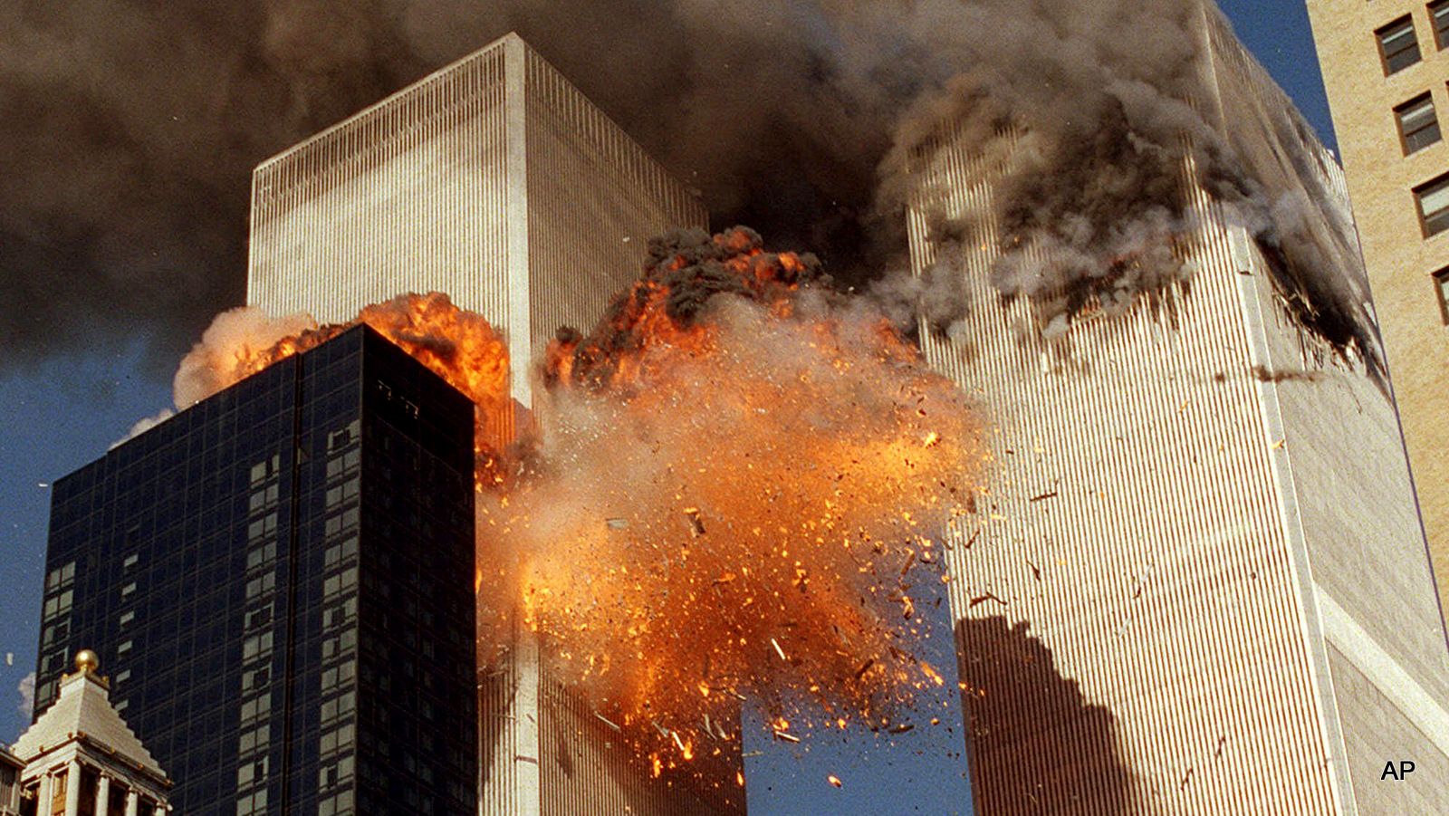 Smoke billows from World Trade Center Tower 1 and flames explode from Tower 2 as it is struck by American Airlines Flight 175, in New York. 
