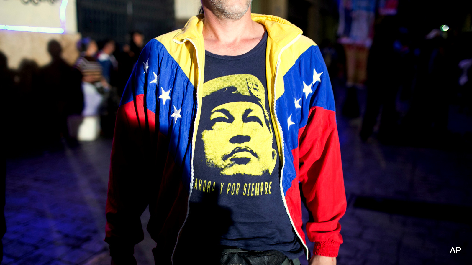 Проправительственный сторонник носит футболку с изображением покойного президента Венесуэлы Уго Чавеса, поскольку он ждет результатов на выборах в Конгресс в Каракасе, Венесуэла, в воскресенье, 6 декабря 2015 года.