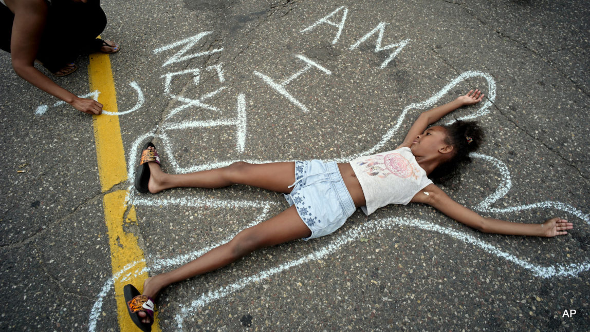 Tia Williams, left, and her daughter Aissa create a display on the street outside the Minnesota governor's official residence Thursday, July 7, 2016, in St. Paul, Minn., as people gathered to protest the shooting death of Philando Castile by police.