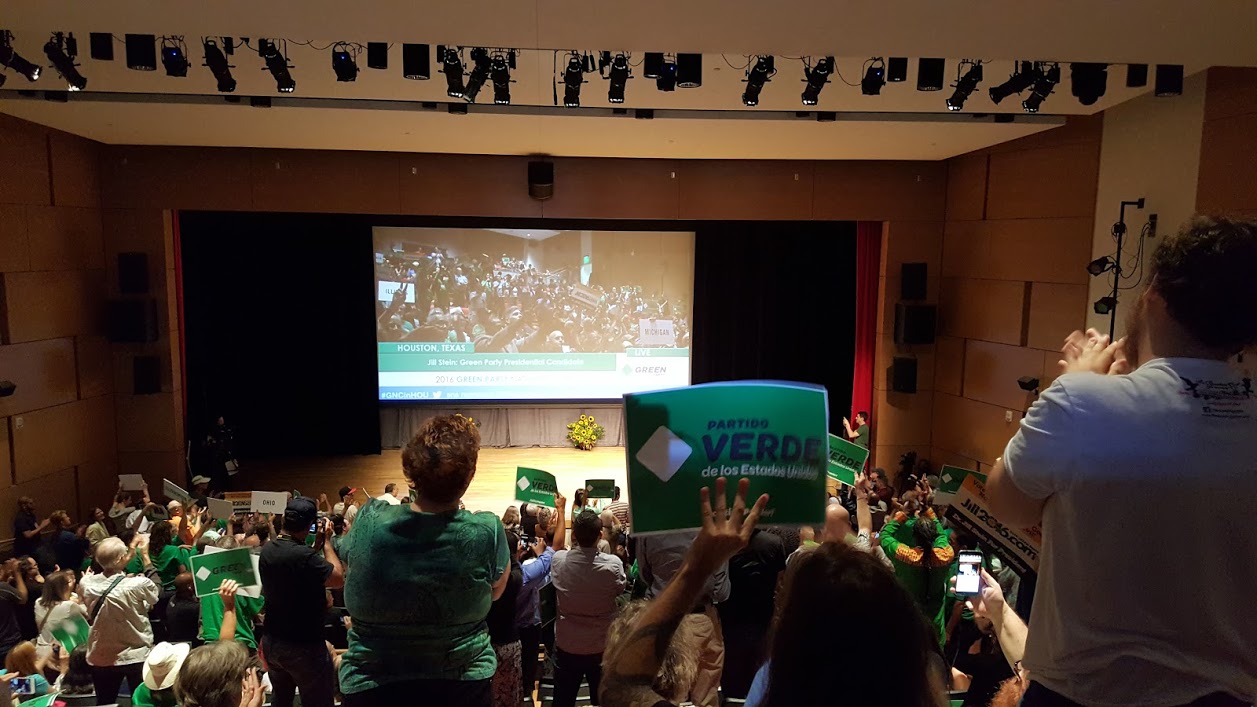 Caption: In this August 6, 2016 photograph, delegates and supporters stand and applaud during the Green Party National Convention at the University of Houston. (MintPress News / Kit O'Connell)