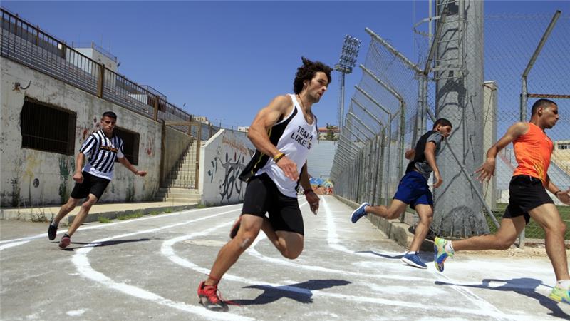 Mohammed al-Khatib warming up before a training session at the local school running track in Hebron. (Photo: Eloise Bollack/Al Jazeera)