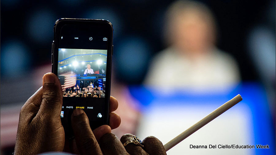 A man takes a photo of Hillary Clinton as she walks on to the stage to accept her nomination from the Democratic Party for president on the final night, July 28, of the Democratic National Convention.