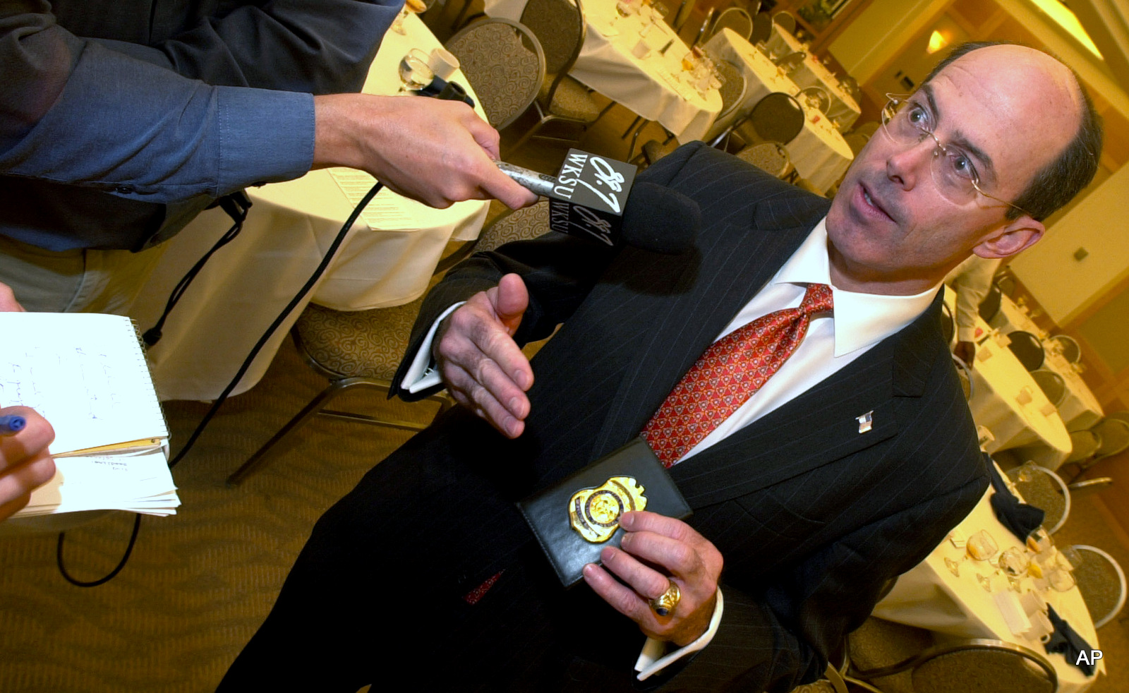 Joseph E. Schmitz, then Inspector General of the U.S. Department of Defense, displays his official badge to reporters, after speaking at the Cleveland City Club, in Cleveland in 2004. 