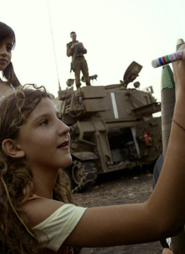 Israeli girls write messages on a bombs at a heavy artillery position near Kiryat Shmona, in northern Israel, next to the Lebanese border, Monday, July 17, 2006. (AP Photo/Sebastian Scheiner)