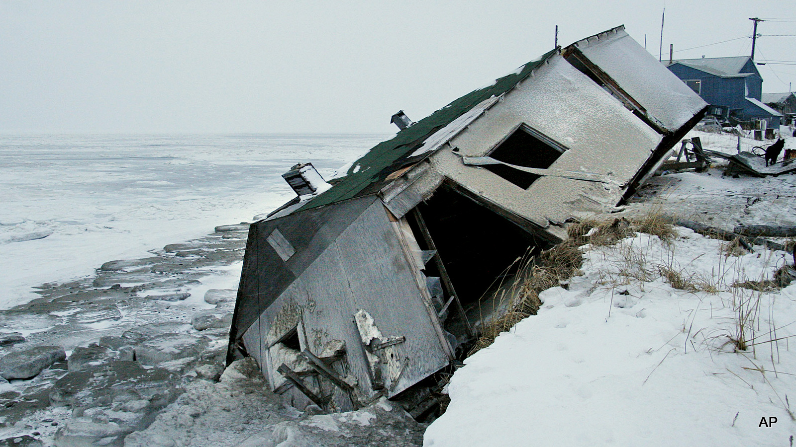 Nathan Weyiouanna's abandoned house at the west end of Shishmaref, Alaska, Dec. 8, 2006, sits on the beach after sliding off during a fall storm in 2005.
