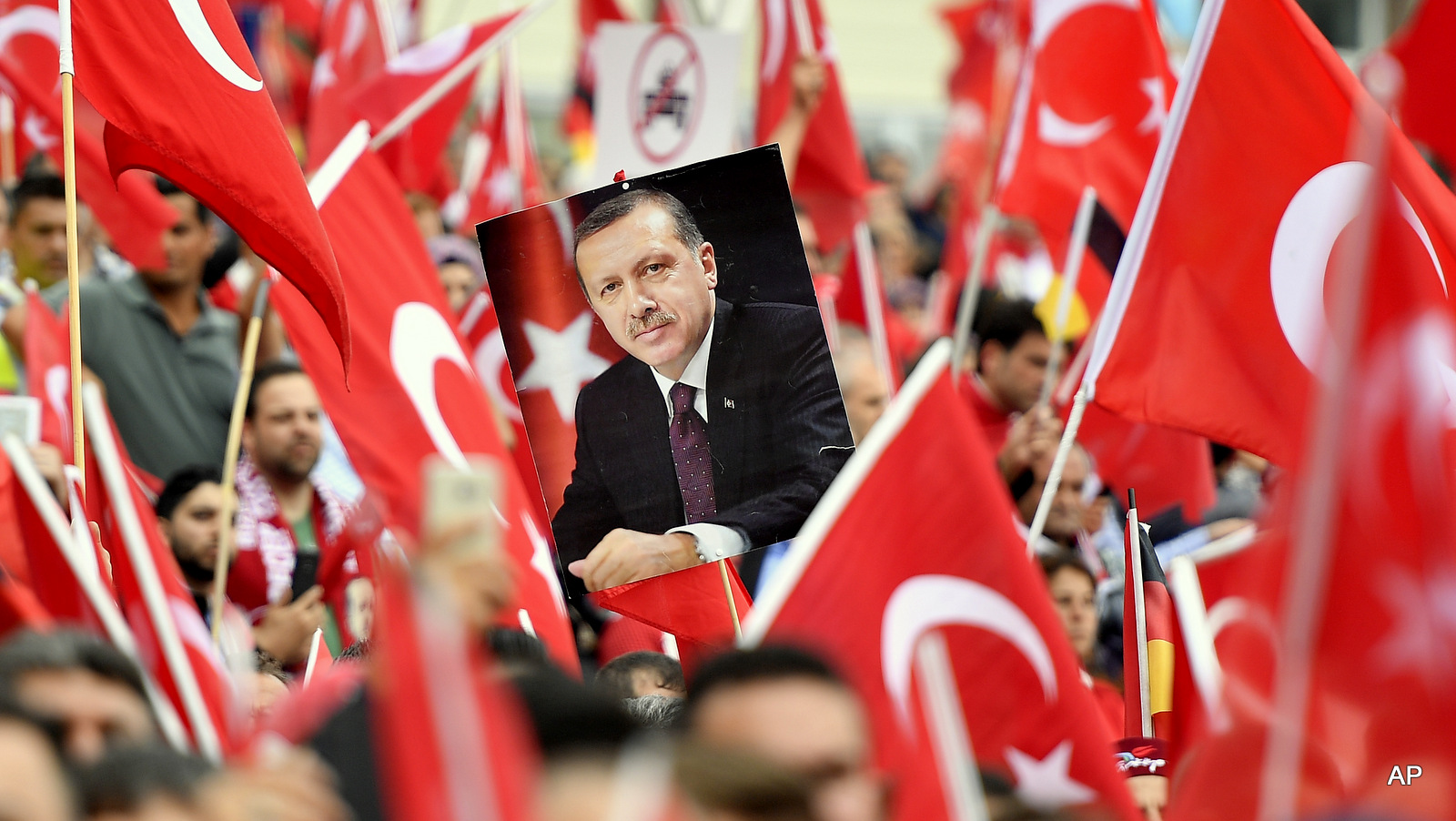 A picture of Turkish president Erdogan is framed by national flags during a demonstration in Cologne, Germany, Sunday, July 31, 2016. Thousands of supporters of Turkish President Recep Tayyip Erdogan gather in the German city of Cologne for a demonstration against the failed July 15 coup in Turkey.