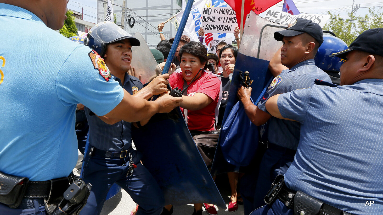 Police scuffle with protesters forcing their way towards the gates of the Heroes Cemetery to oppose next month's burial of the late Philippine dictator Ferdinand Marcos at the cemetery, Thursday, Aug. 18, 2016, in suburban Taguig city east of Manila, Philippines. Various civic and anti-Marcos groups have revived their protests after President Rodrigo Duterte ordered Marcos' burial with full military honors.
