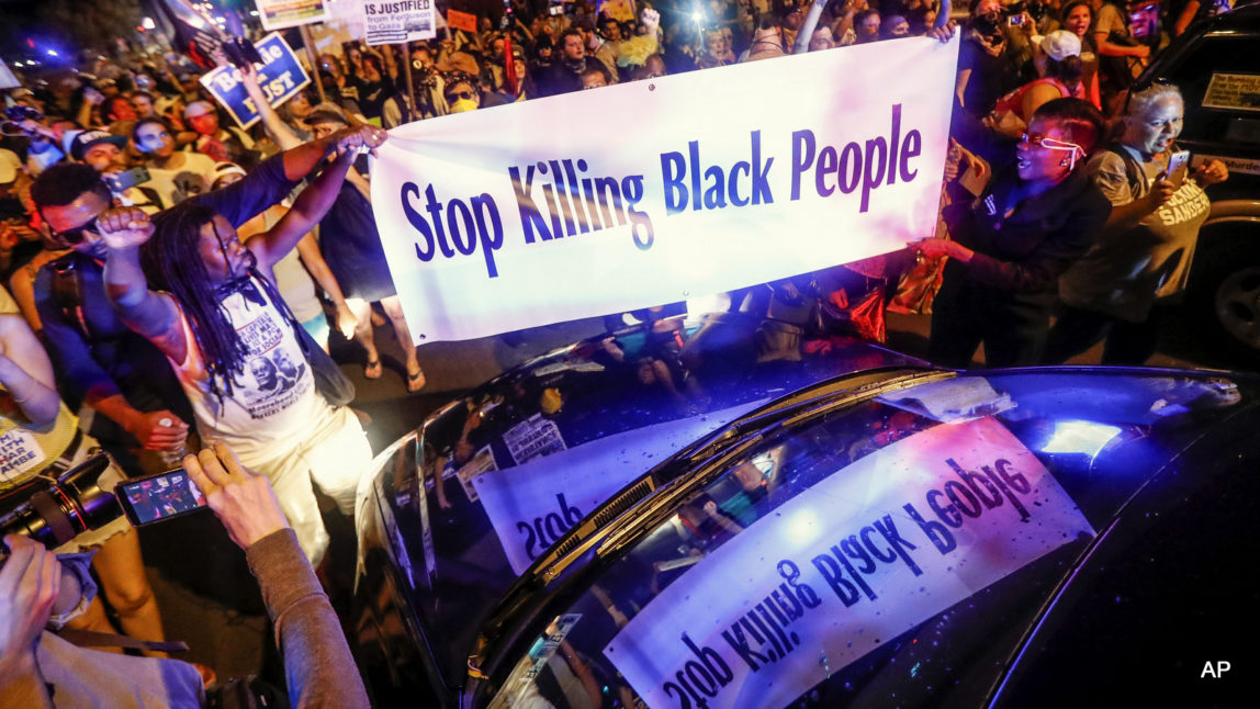 Black Lives Matter demonstrators gather at the police vehicle stuck facing northbound during a protest march south on Broad Street in Philadelphia, Tuesday, July 26, 2016, during the second day of the Democratic National Convention.