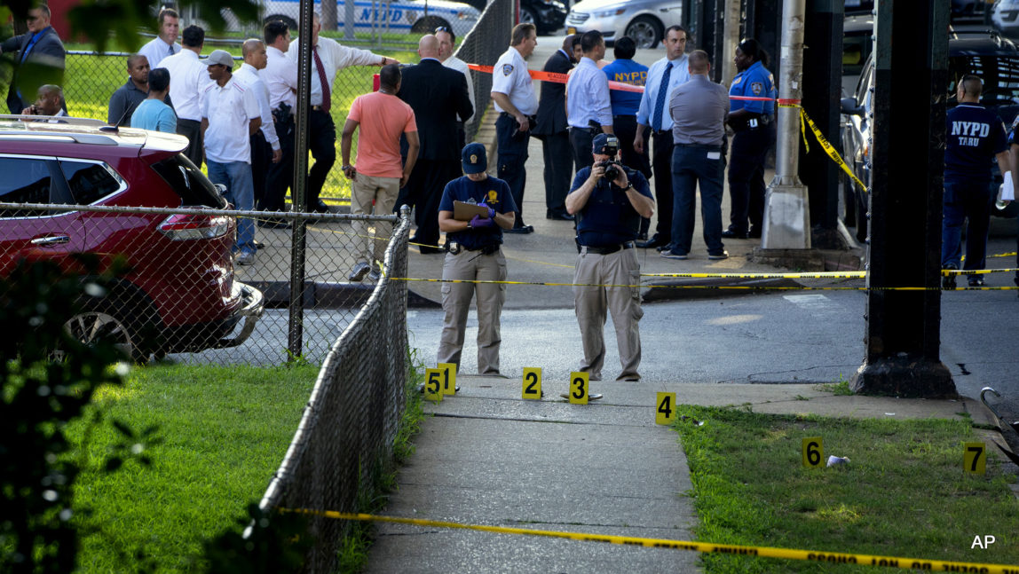 New York police department crime scene investigators photograph evidence Saturday, Aug. 13, 2016, in the Queens borough of New York, after the leader of a New York City mosque and an associate were fatally shot as they left afternoon prayers. Police said 55-year-old Imam Maulama Akonjee and his 64-year-old associate, Tharam Uddin, were shot as they left the Al-Furqan mosque.