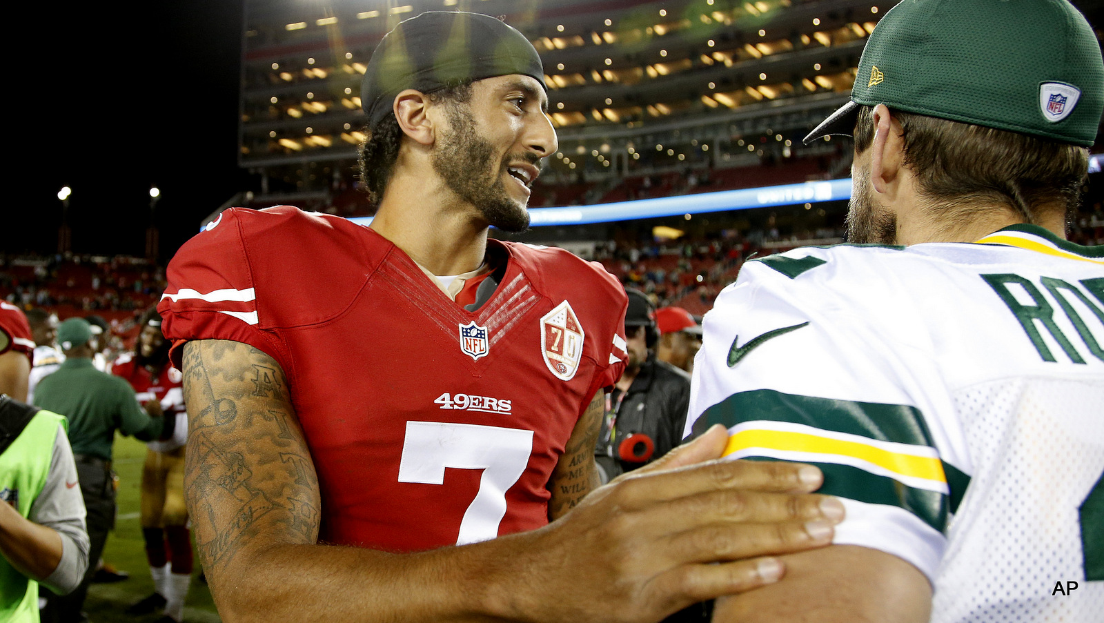San Francisco 49ers quarterback Colin Kaepernick, left, greets Green Bay Packers quarterback Aaron Rodgers at the end of an NFL preseason football game Friday, Aug. 26, 2016, in Santa Clara, Calif.