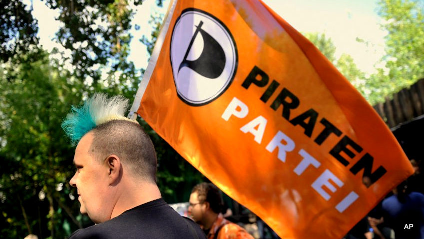 A member of Germany's Pirate Party holds a flag of the party (Credit: AP/Gero Breloer)
