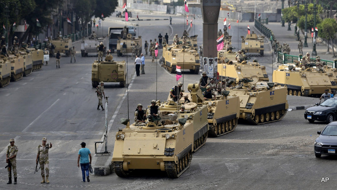 Egyptian army soldiers take their positions on top and next to their armored vehiclesin Cairo, Egypt, Friday, Aug. 16, 2013. (AP Photo/Hassan Ammar)