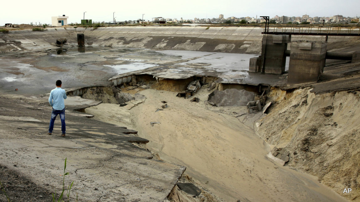 A Palestinian man walks near a sewage reservoir after it has collapsed causing a flood and damaging farms in Sheikh Ejleen neighborhood of Gaza City, Wednesday, May 4, 2016. A sewage reservoir in Gaza has collapsed, flooding about 25 acres of farmland and signaling yet another warning over the need to address the exacerbating water and sewage crisis. On Wednesday, sewer trucks were still sucking wastewater pools from unpaved lanes, groves, chicken farms and beehives in Sheikh Ejleen neighborhood, south Gaza City, a day after one side of the pond collapsed.