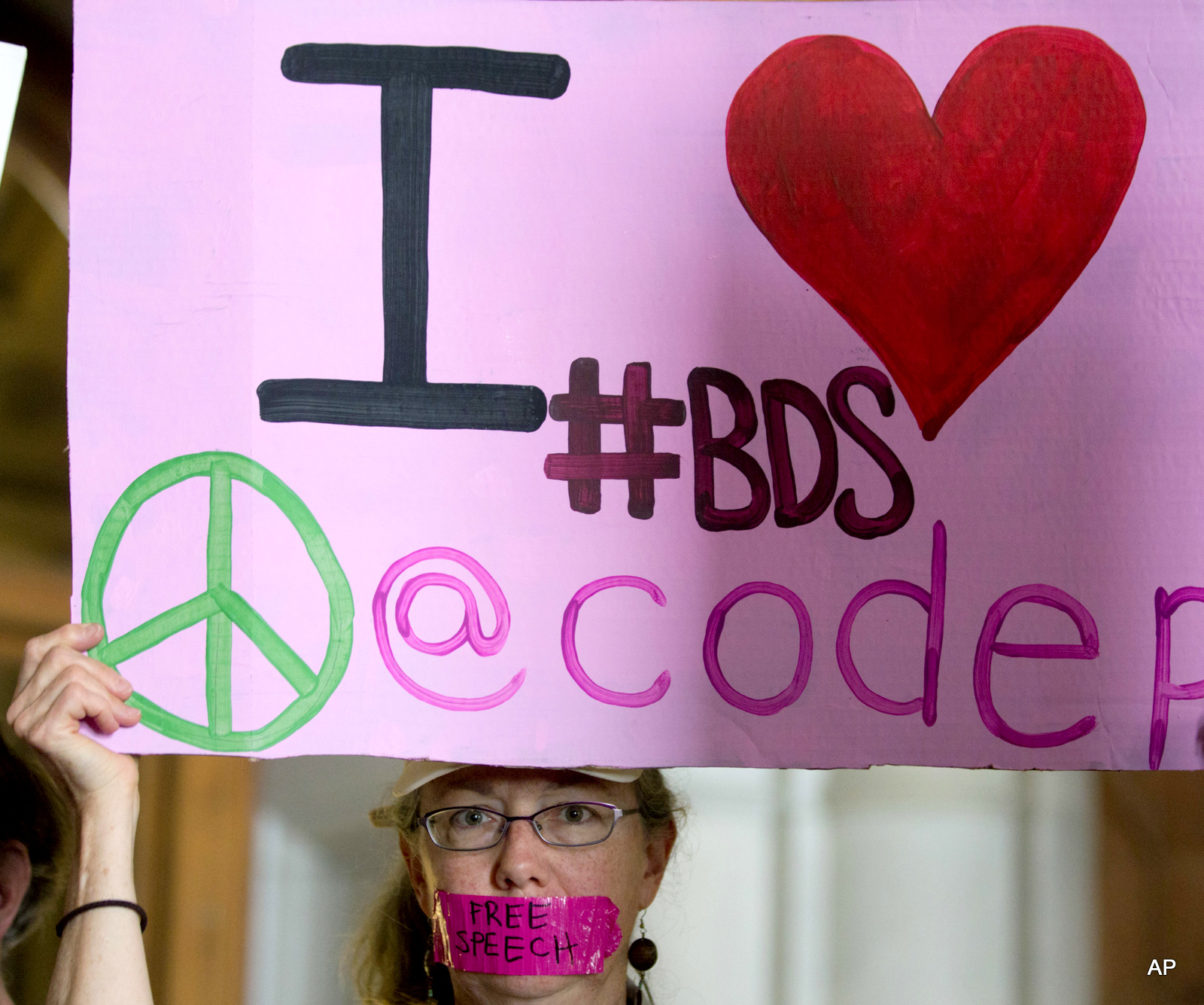 Mary Anne Grady Flores of Ithaca, N.Y., wears tape over her mouth during a rally in the War Room at the state Capitol on Wednesday, June 15, 2016, in Albany, N.Y. Critics of Israel's treatment of Palestinians protested Gov. Andrew Cuomo's executive order prohibiting state investments in any company that supports a boycott of Israel.