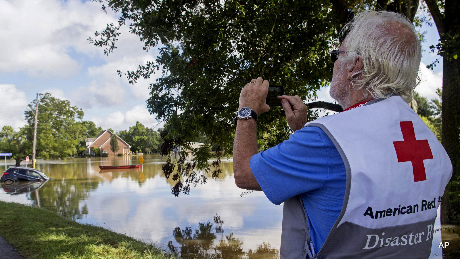 James Hennessy, a Red Cross mental health volunteer from Tallahassee, Florida, takes a photo of Old Jefferson Highway which he was hoping to cross to reach Baton Rouge in Prairieville, La., Tuesday, Aug. 16, 2016.