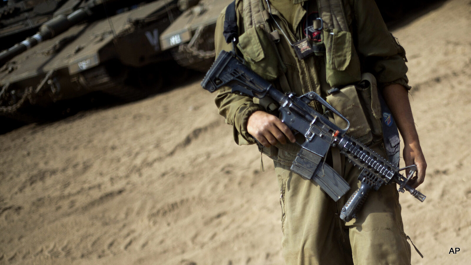 An Israeli soldier walks past tanks during training in the Israeli-occupied Golan Heights, near the border with Syria, Tuesday, Sept. 13, 2016.