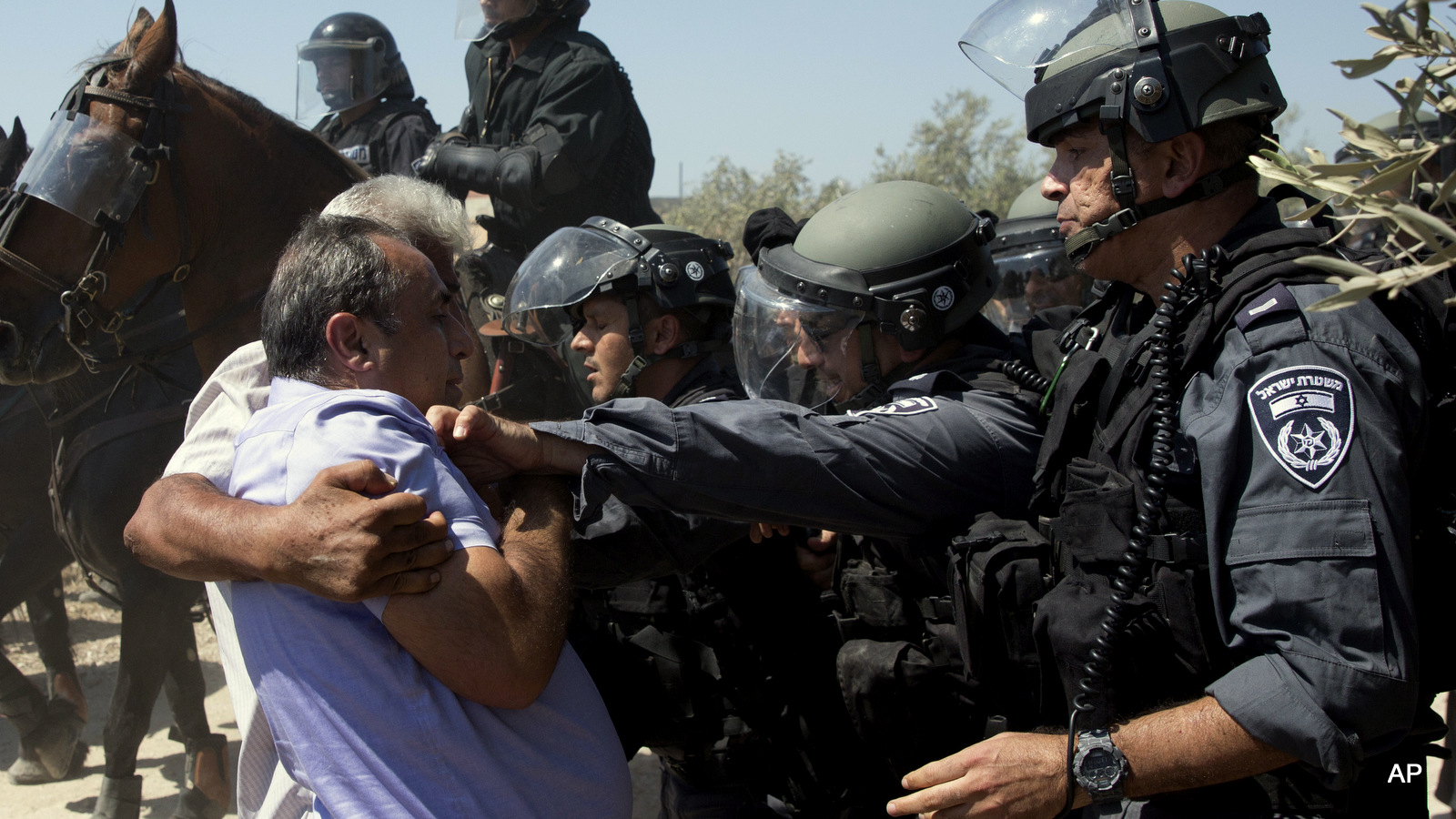Israeli riot police officers scuffle with Arab men in Arab village of Ara, northern Israel, Monday, Sept. 19, 2016. About 50 right wing activists protested in Ara outside the home of Nashhat Milhem, who killed three people in a shooting rampage in Tel Aviv in January 2016 before police killed him in a shootout. The demonstrators demanded Israel deport Milhem's family and shouted "There is no Palestine." They arrived under heavy police escort to the village, where locals held a counterdemonstration.