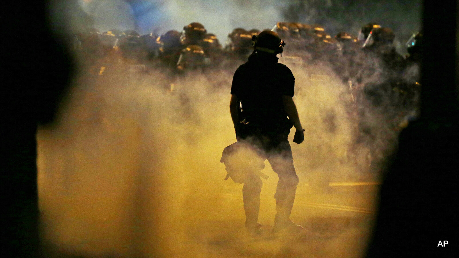 Police fire teargas as protestors converge on downtown following Tuesday's police shooting of Keith Lamont Scott in Charlotte, N.C., Wednesday, Sept. 21, 2016. Protesters have rushed police in riot gear at a downtown Charlotte hotel and officers have fired tear gas to disperse the crowd. At least one person was injured in the confrontation, though it wasn't immediately clear how. Firefighters rushed in to pull the man to a waiting ambulance.