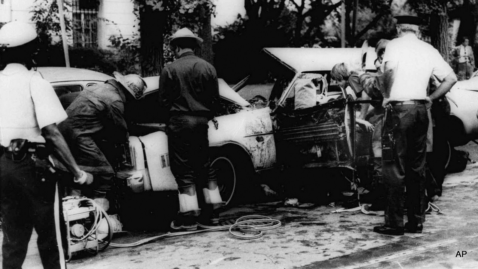 FILE - In this Sept. 21, 1976 black-and-white file photo, firemen remove victims from a car shattered by a bomb blast on Embassy Row in Washington. Orlando Letelier, former Chilean ambassador to the U.S., and Ronne Karpen Moffitt, his aide, were both killed in the blast. As secretary of state, Henry Kissinger canceled a U.S. warning against carrying out international political assassinations that was to have gone to Chile and two neighboring nations just days before a former ambassador was killed by Chilean agents on Washington's Embassy Row in 1976.