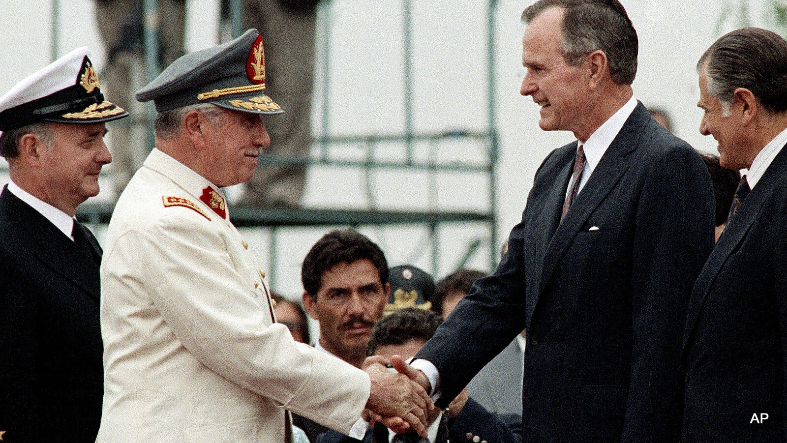 Pres. George H. W. Bush, center, shakes hands with former Chilean dictator Gen. Augusto Pinochet, Dec. 6, 1990, Santiago, Chile.