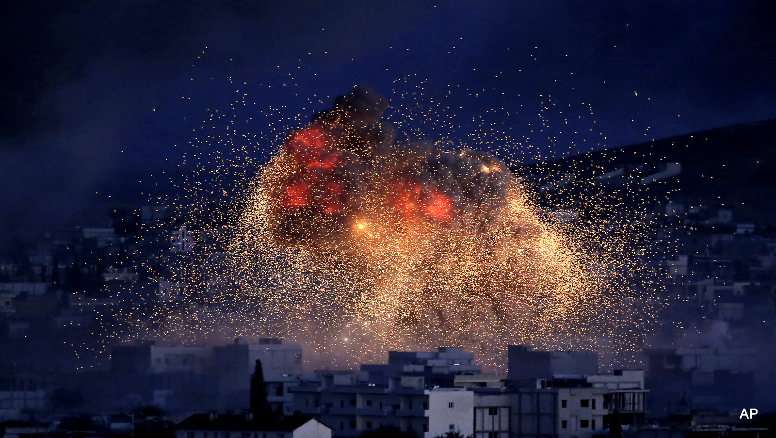 Thick smoke and flames erupt from an airstrike by the U.S.-led coalition in Kobani, Syria, as seen from a hilltop on the outskirts of Suruc, at the Turkey-Syria border.