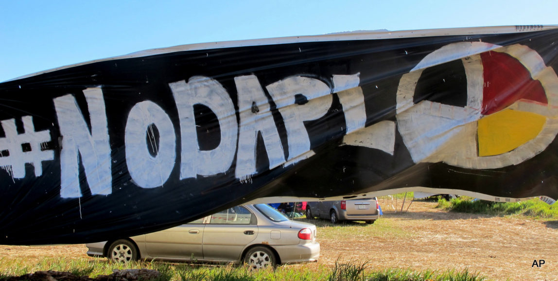A banner protesting the Dakota Access oil pipeline is displayed at an encampment near North Dakota's Standing Rock Sioux reservation on Friday, Sept. 9, 2016. The Standing Rock Sioux tribe's attempt to halt construction of an oil pipeline near its North Dakota reservation failed in federal court Friday, but three government agencies asked the pipeline company to "voluntarily pause" work on a segment that tribal officials say holds sacred artifacts. (AP Photo/James MacPherson)