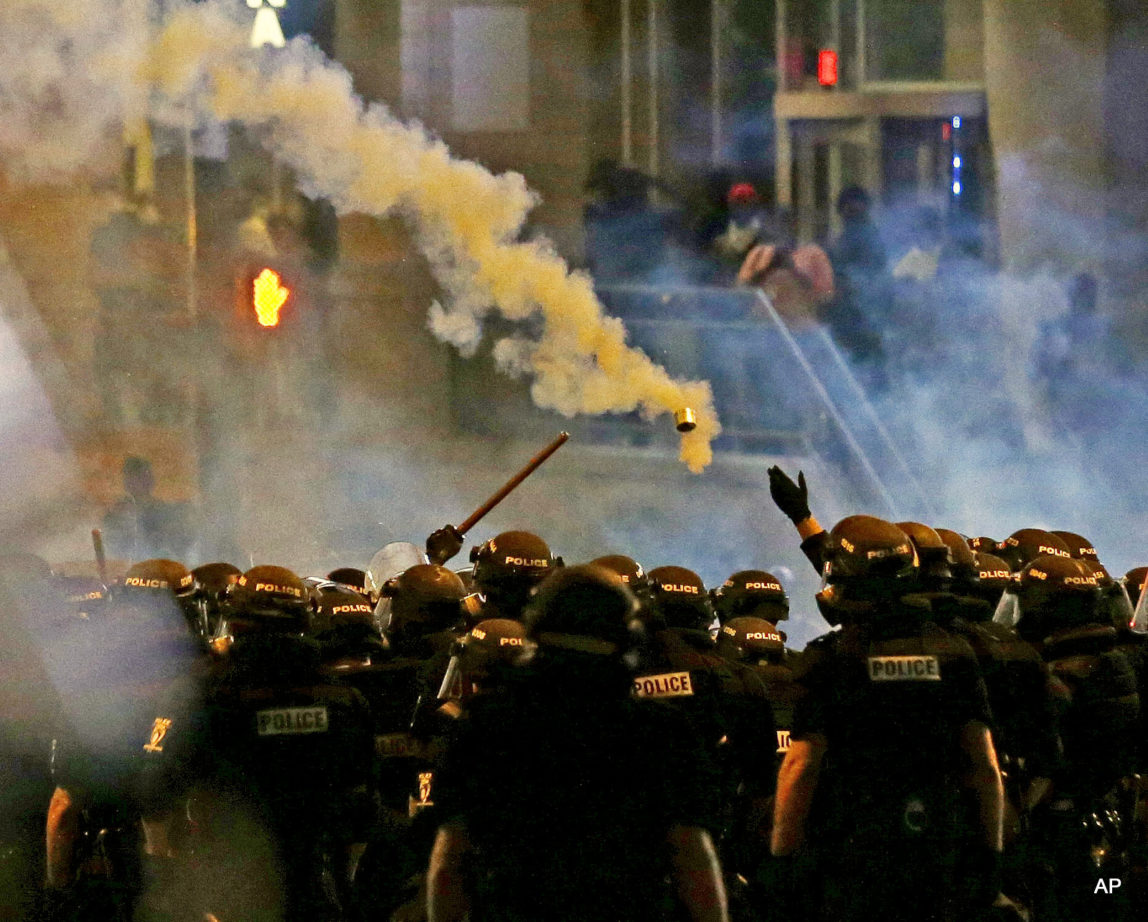 Police fire tear gas as protestors converge downtown following Tuesday's police shooting of Keith Lamont Scott in Charlotte, N.C., Wednesday, Sept. 21, 2016.