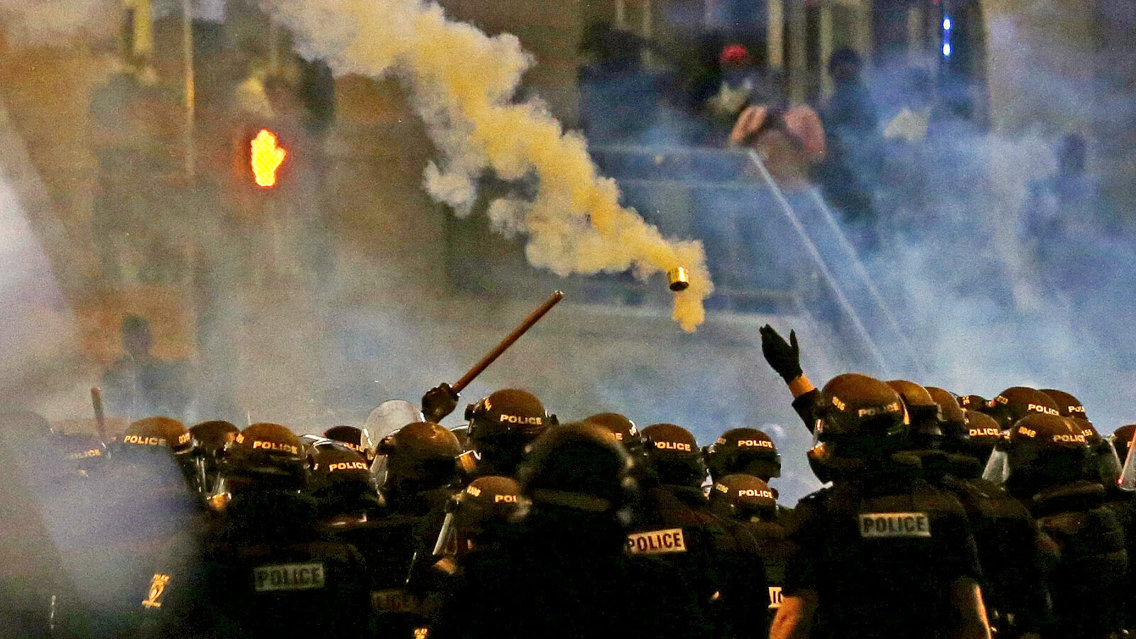 Police fire tear gas as protestors converge downtown following Tuesday's police shooting of Keith Lamont Scott in Charlotte, N.C., Wednesday, Sept. 21, 2016.