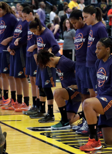 This Sept. 21, 2016, file photo shows, Phoenix Mercury's Kelsey Bone, right, and Mistie Bass, second from right, kneeling during the playing of the national anthem before the start of a first round WNBA playoff basketball game a in Indianapolis.