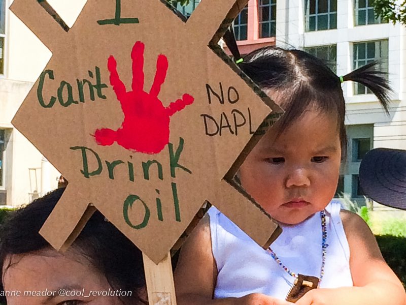 A Native American girl holds a sign which reads, 'I can't drink oil," at a protest against the Dakota Access Pipeline. August 24, 2016. (Flickr / cool revolution)